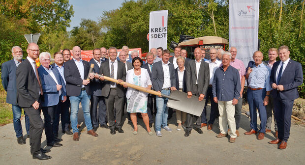 Vertreter aus Politik, Verwaltung und Wirtschaft beim ersten Spatenstich für den Breitbandausbau im Kreis Soest. In der Mitte: Landrätin Eva Irrgang (CDU). Am Griff des überdimensionalen Spatens (links): Breitbandkoordinator Christoph Hellmann. Und ganz links: Ortsvorsteher Edmung Schmidt (CDU) aus Wimbern. FOTO: THOMAS WEINSTOCK / KREIS SOEST