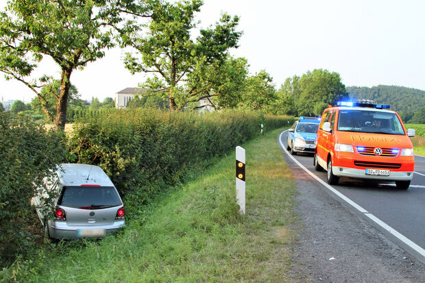 Das verunglückte Fahrzeug im Graben und Einsatzfahrzeuge auf der Mendener Straße in Wimbern FOTO: ANDREAS DUNKER