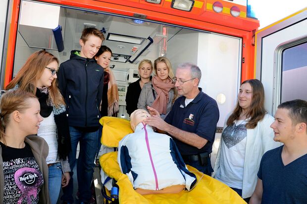 Neben sechs weiteren Berufsfeldern, wird auch im Berufsfeld Medizin und Gesundheit durch den Rettungsdienst des Kreises Soest ein interessantes Angebot von zwölf Plätzen vorgehalten. Hans-Peter Trilling (3. v. r.), Ärztlicher Leiter des Rettungsdienstes des Kreises Soest, demonstriert hier interessierten Schülerinnen und Schülern, wie man Leben rettet. FOTO: THOMAS WEINSTOCK / KREIS SOEST  