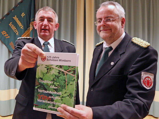 Bei der Generalversammlung der Schützenbruderschaft St. Johannes Wimbern präsentierten Vorsitzender Hubert Linhoff und Brudermeister Gerhard „Gerry“ Schulte (rechts) einen Vorabdruck der 312-seitigen Chronik „125 Jahre Schützen Wimbern: Tradition leben – Verbundeheit schaffen – Verantwortung übernehmen“ FOTO: ANDREAS DUNKER