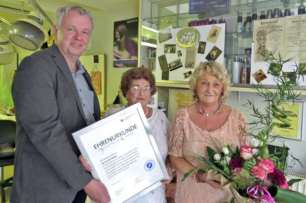Friseurmeisterin Jutta Neumann (63, rechts) hat den Familienbetrieb "Salon Hoffmann" an ihre bisherige Angestellte Maribel Pinheiro (38) übergeben. – Die Aufnahme entstand anlässlich des 100. Jubiläums des Handwerkbetriebes. Links: Obermeister Norbert Bitter von der Friseur-Innung Soest-Lippstadt. Und in der Mitte: Alt-Chefin Anne-Lore Hoffmann († 2018) ARCHIVFOTO: KREISHANDWERKERSCHAFT / FRISEURINNUNG