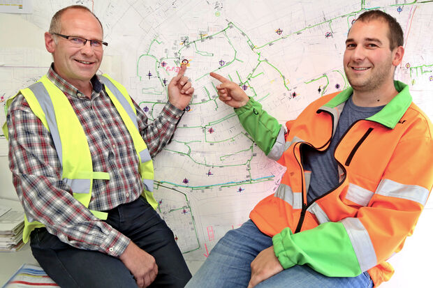 Bauleiter Jürgen Kühn (links) von Deutsche Glasfaser und Stefan Heisterkamp (rechts) vom beauftragten Generalbauunternehmen für Wickede und Echthausen vor einem Übersichtsplan mit fertigen Strecken (grün) FOTO: ANDREAS DUNKER