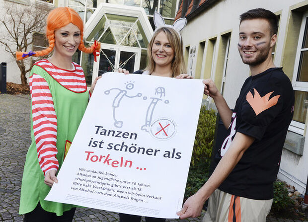 Die Auszubildenden (von links): Daniela Fischer, Sandrin Schramke und Maximilian Boehmer präsentieren das Plakat zur Gesundheits- und Jugendschutzkampagne „Tanzen ist schöner als Torkeln …“. Es ist unter anderem in Bussen und Kiosken im Kreisgebiet zu sehen. FOTO: THOMAS WEINSTOCK / KREIS SOEST