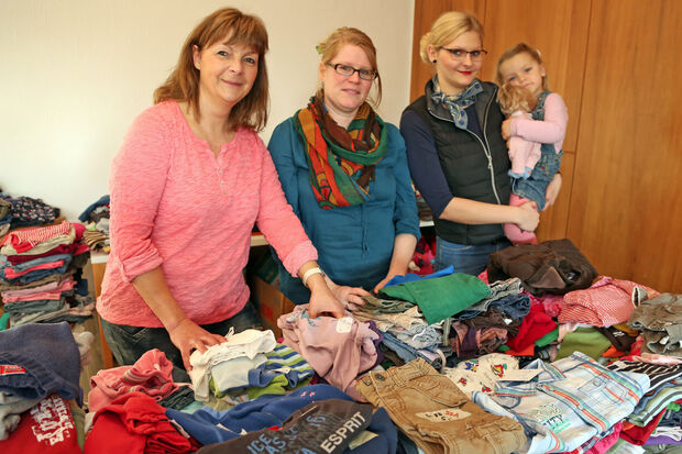 Helferinnen vor den Stapeln mit "Kinderklamotten" FOTO: ANDREAS DUNKER