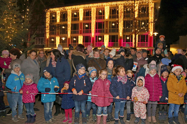 Zwischen dem festlich geschmückten Weihnachtsbaum auf dem Marktplatz und dem illuminierten Rathaus drängten sich zahlreiche Kinder mit ihren Eltern, Großeltern und weiteren Begleitern beim Nikolaus-Besuch in Wickede. FOTO: ANDREAS DUNKER