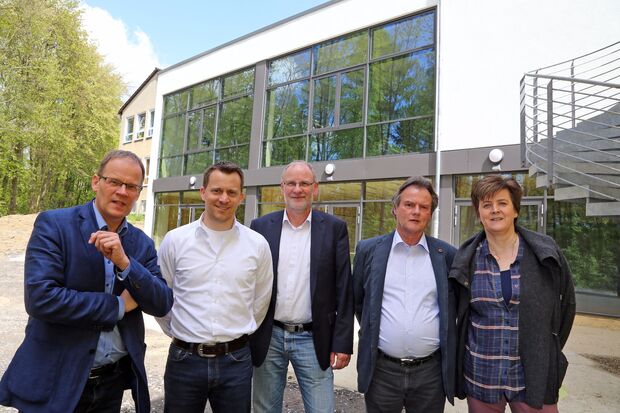 Die Fensterfront des neuen Forums bietet schöne Aussichten in den benachbarten Erbke-Wald. – Von links: Bürgermeister Dr. Martin Michalzik (CDU) und Sekundarschulleiter Jan Haurand  sowie Fachbereichsleiter Markus Kleindopp, Frank Knop vom Bauamt und Susanne Modler vom Schulamt der Gemeindeverwaltung. FOTO: ANDREAS DUNKER