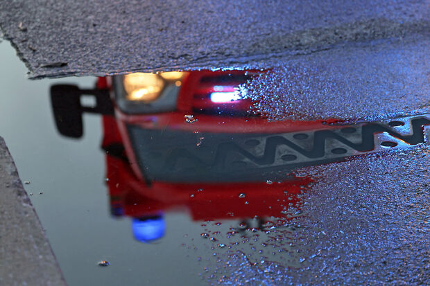 Das Blaulicht des Rettungsdienstes spiegelt sich in einer Pfütze auf der regennassen Fahrbahn der Ruhrbrücke. FOTO: ANDREAS DUNKER