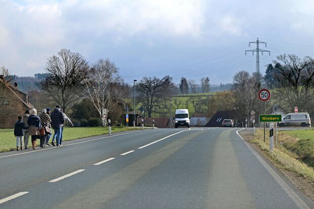 Flüchtlinge laufen am Straßenrand in Richtung des neuen Einzelhandelgeschäftes in Wimbern FOTO: ANDREAS DUNKER