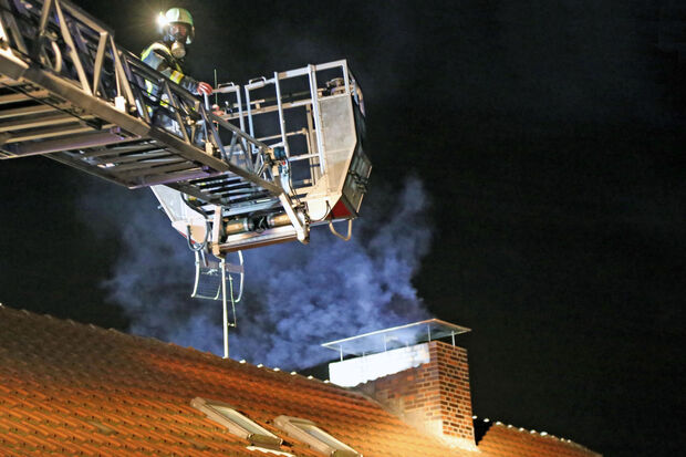 Kaminbrand am Buchenweg: Feuerwehrmann auf der Drehleiter FOTO: ANDREAS DUNKER