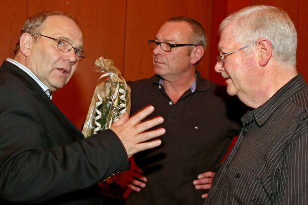 VHS-Leiter Wolfgang Klesse bekam zum Abschied von den Bürgerhaus-Hausmeistern Günter Gutland und Kevin Cheshire einen guten Tropfen aus der Ruhrgemeinde (von links). FOTO: ANDREAS DUNKER
