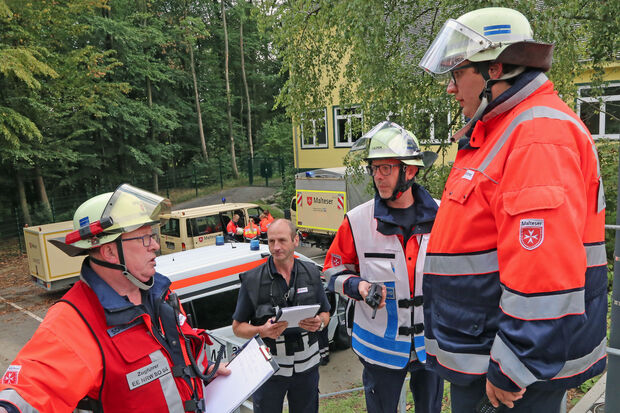 Lagebesprechung der Malteser-Führung auf der Schulhof-Treppe FOTO: ANDREAS DUNKER