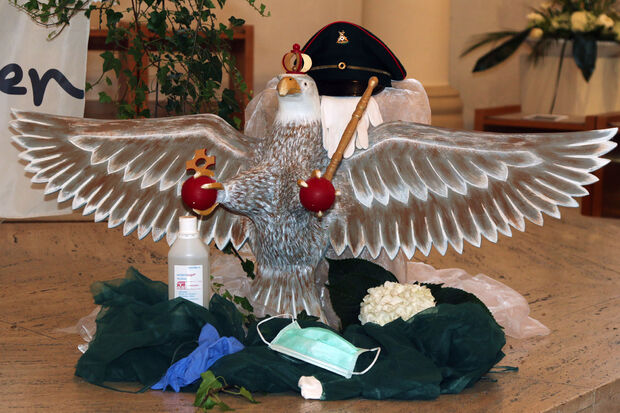 Mit Mundschutz, Desinfektionsspray und Einweghandschuhen – der neue Schützenvogel wurde von Hygienebeauftragten und Regenten Rainer Belz "dekoriert". FOTO: ANDREAS DUNKER