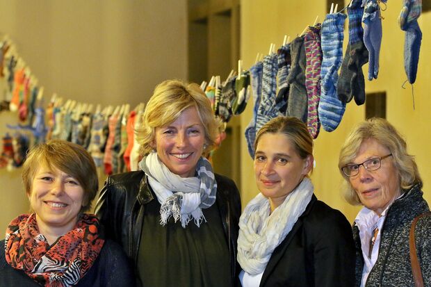 Ganz von den Socken: Natalia Klassen, Herta Yazigi, Ilona Fischer und Inge Gabrecht (von links) vor der Wäscheleine voller selbst gestrickter Strümpfe in der evangelischen Christus-Kirche FOTO: ANDREAS DUNKER