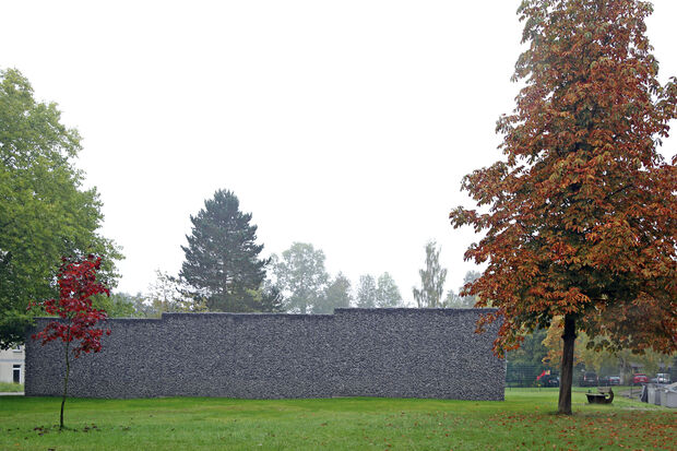 Ein Schildbürgerstreich: Eine Gabionenwand steht einsam auf dem Rasen zwischen ZUE und KiTa. – Das teure Bauwerk sollte eigentlich als Schallschutz für den geplanten Bolzplatz dienen, der nun eventuell gar nicht mehr gebaut wird. ARCHIVFOTO: ANDREAS DUNKER